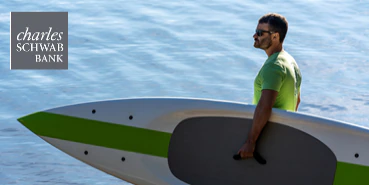 Man carrying surfboard by the beach